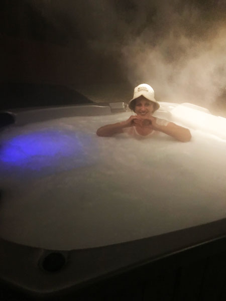 Karen Duquette in the hot tub on a snowy nigh